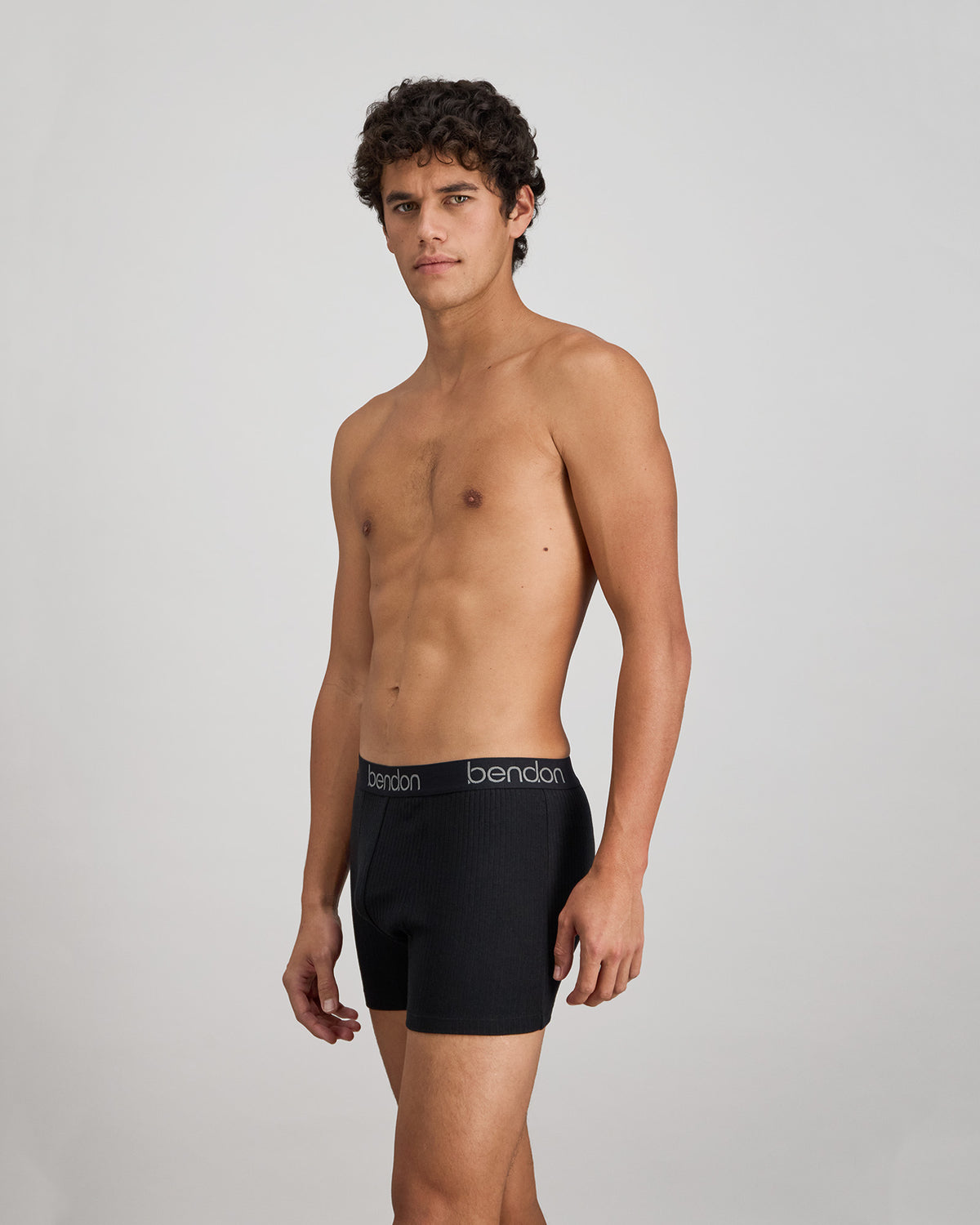 Model wears Cotton Texture Mens Trunk in BLACK. On body side view