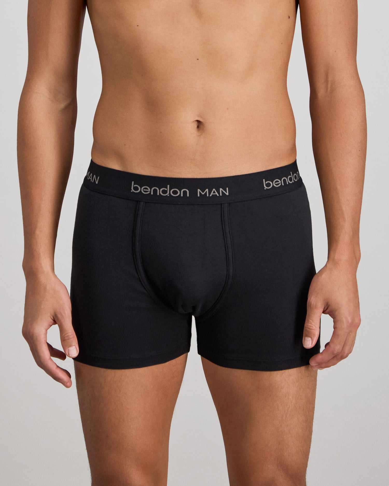 Model wears Cotton Classics Mens Trunk in BLACK. On body front view