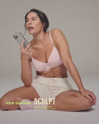 model-poses-with-phone-in-light-pink-lingerie-set