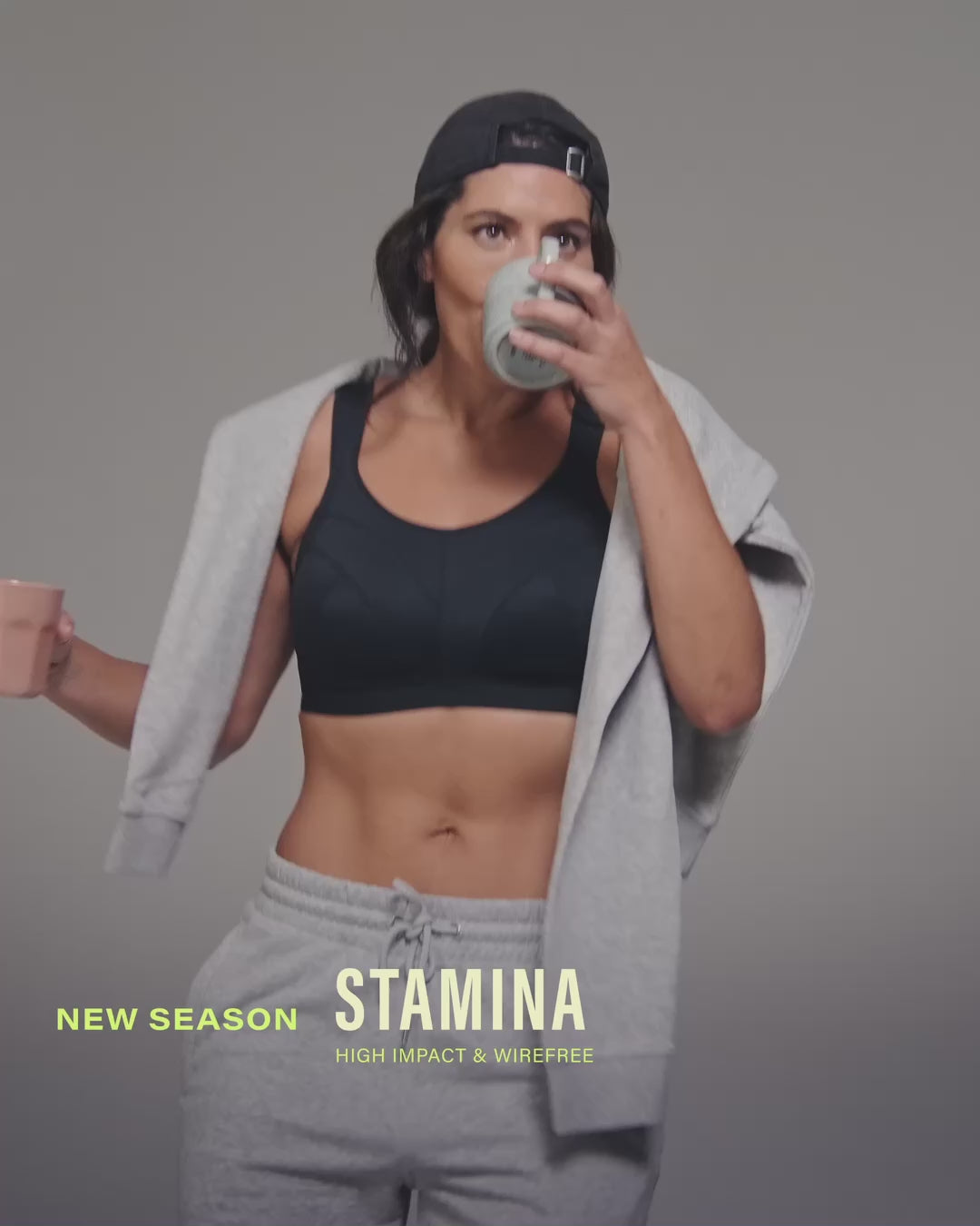 model-holds-two-coffee-cups-wearing-black-sports-bra