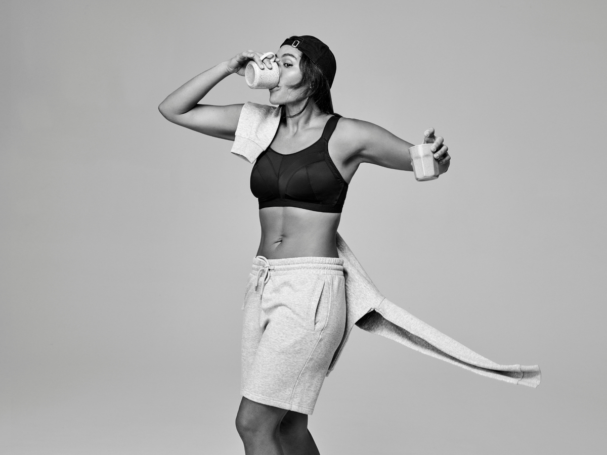 Person in athletic wear with a towel draped over their shoulder against a plain background